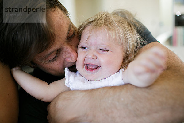 Mittelgroßer Erwachsener Mann umarmt Baby-Tochter