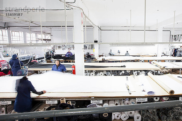 Fabrikarbeiterinnen rollen Textilien in Bekleidungsfabrik ab