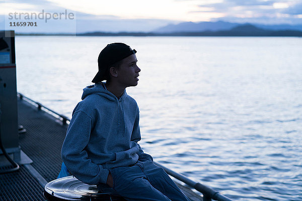 Teenager  der auf dem Dock sitzt und wegschaut  Pacific Rim National Park  Vancouver Island  Kanada