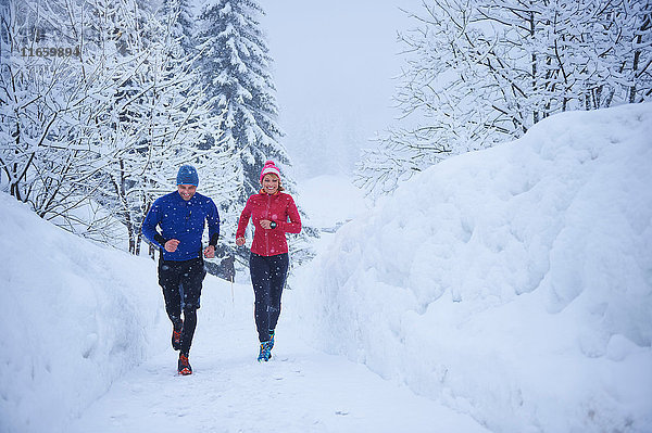 Läuferinnen und Läufer laufen bei Schneefall  Gstaad  Schweiz