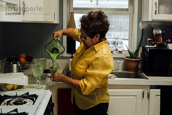 Frau gießt Smoothie ein