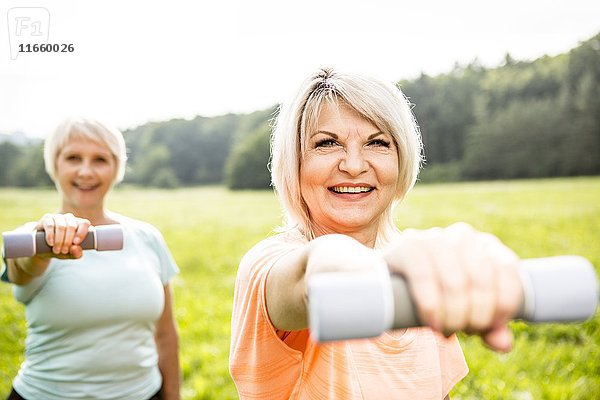 Zwei Frauen trainieren mit Handgewichten.