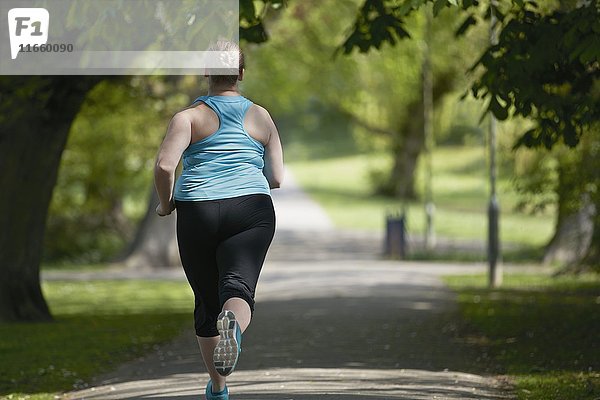 Junge Frau läuft auf einem Weg  Rückansicht.