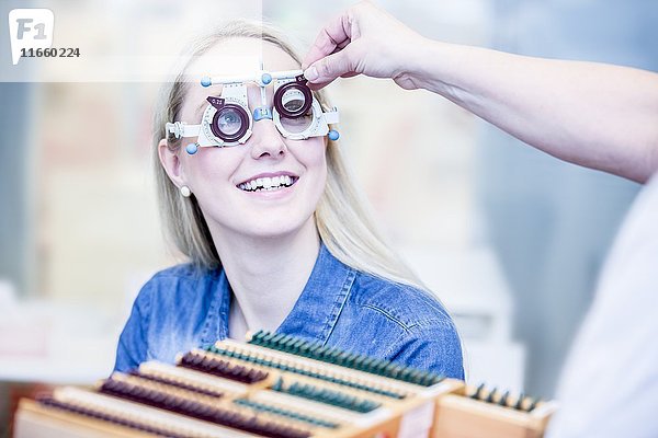 Fröhliche junge Frau bei einer Augenuntersuchung in einem Optikergeschäft  Nahaufnahme.