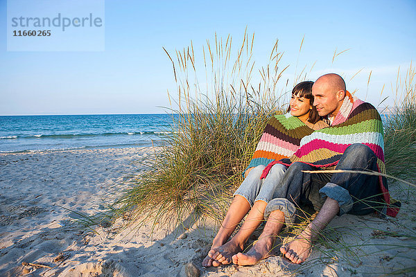 Mit einer Decke bedecktes Ehepaar auf einer Sanddüne  Mallorca  Spanien