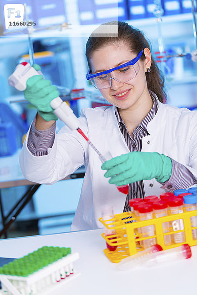 Eine Wissenschaftlerin benutzt eine Pipette im Labor.