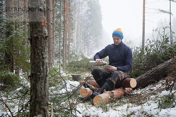 Holzfäller macht Pause bei Baumstämmen  Tammela  Forssa  Finnland