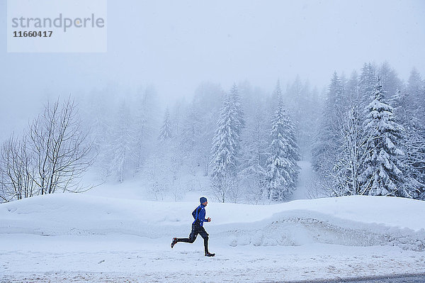 Fernansicht eines männlichen Läufers  der im Tiefschnee läuft  Gstaad  Schweiz