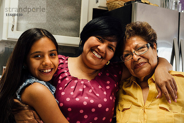 Porträt einer Mehrgenerationen-Familie  die lächelnd in die Kamera schaut