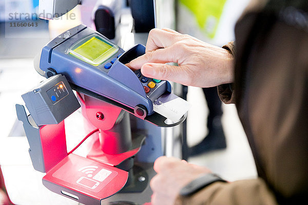 Ältere Frau benutzt Kreditkartenautomat zum Bezahlen von Einkäufen  Nahaufnahme