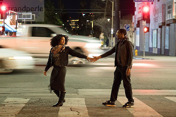 Paar hält Hände auf einem Fußgängerüberweg  Los Angeles  Kalifornien  USA