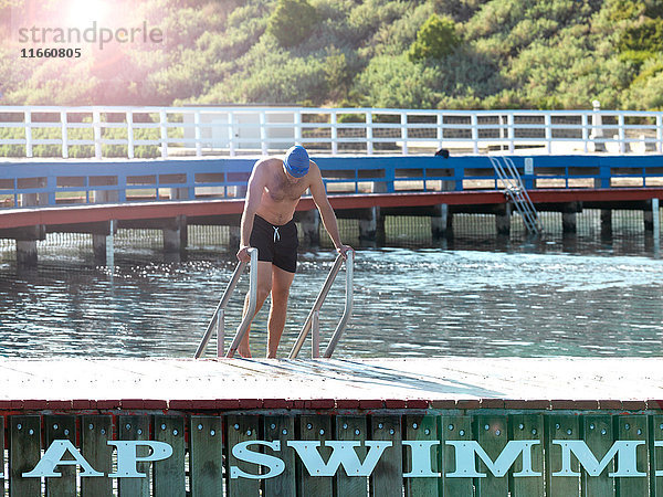 Schwimmer  der auf einer Leiter aus dem Wasser aufsteigt  Eastern Beach  Geelong  Victoria  Australien