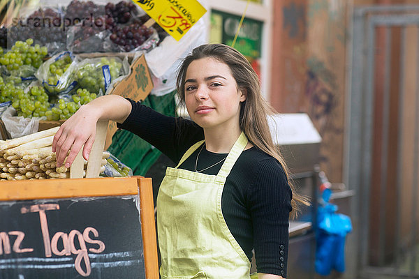 Porträt einer jungen weiblichen Obst- und Gemüsestandhändlerin