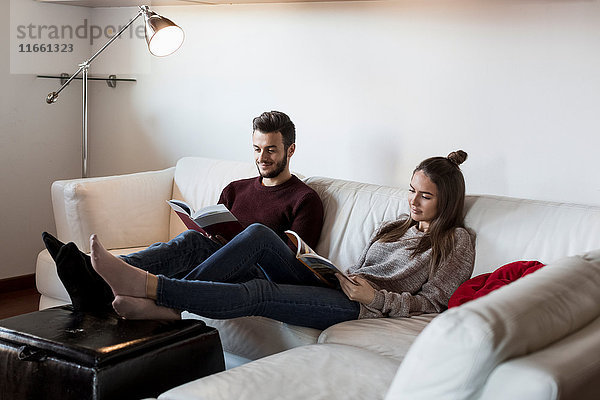 Junges Paar  auf dem Sofa entspannen  Zeitschriften lesen