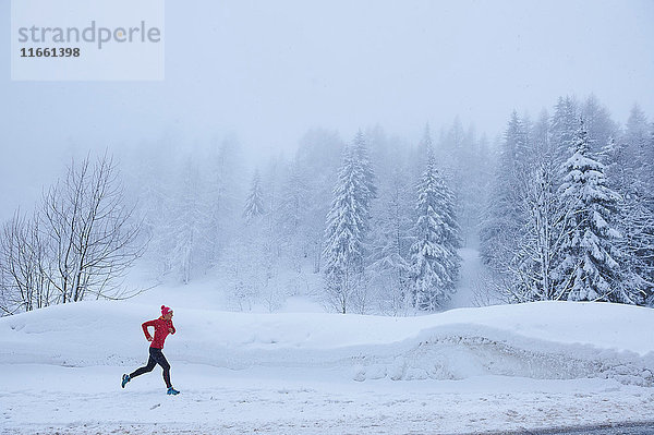 Distanzansicht einer Läuferin beim Laufen im Tiefschnee  Gstaad  Schweiz