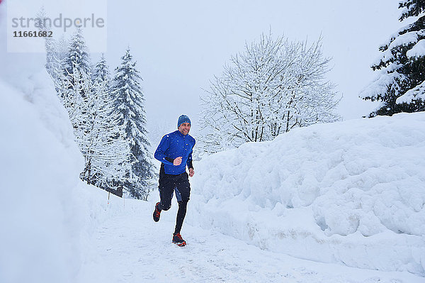 Männlicher Läufer läuft auf der Bahn im Tiefschnee  Gstaad  Schweiz