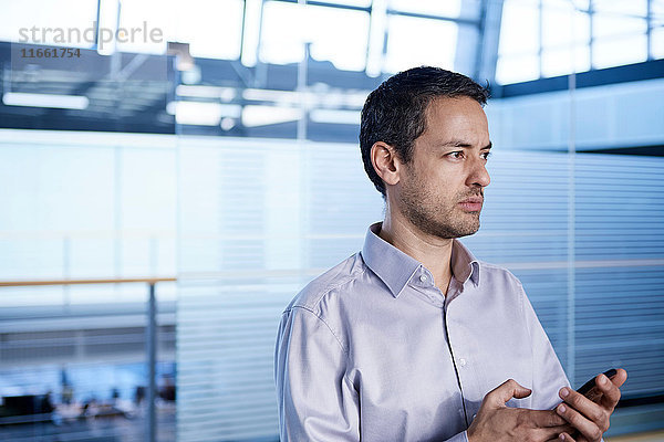 Geschäftsmann mit Smartphone im Büro