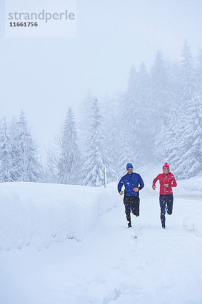 Läuferinnen und Läufer laufen bei Schneefall  Gstaad  Schweiz
