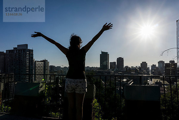 Frau mit erhobenen Armen beim Blick auf Santiago de Chile  Chile