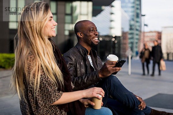 Glückliches junges Paar beim Kaffee zum Mitnehmen in der Stadt