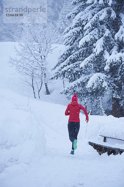 Rückansicht einer Läuferin  die im Tiefschnee auf der Bahn läuft  Gstaad  Schweiz