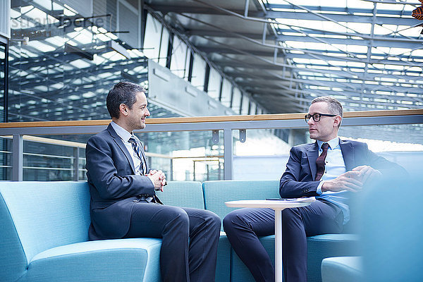 Treffen von Geschäftsleuten auf dem Sofa im Atrium des Büros