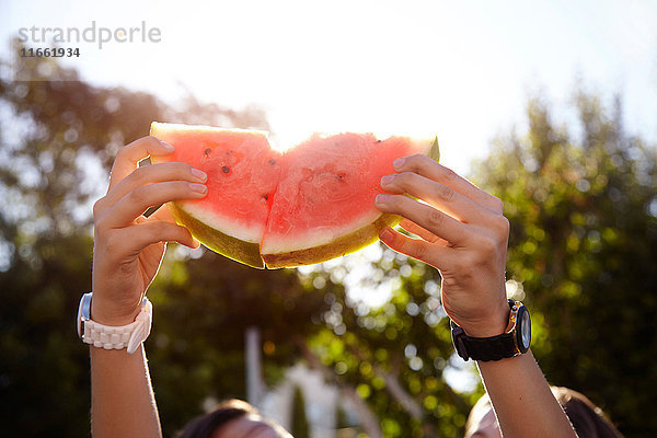 Teenager-Mädchen halten Wassermelone auf der Straße hoch