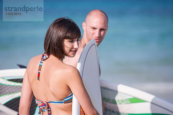 Paar mit Surfbrettern am Meer  Mallorca  Spanien