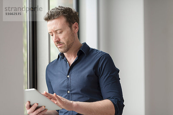 Mann benutzt digitales Tablett durch Bürofenster