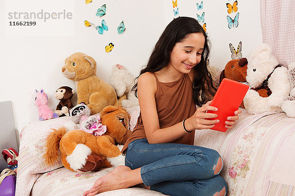 Mädchen im Bett mit digitalem Tablett