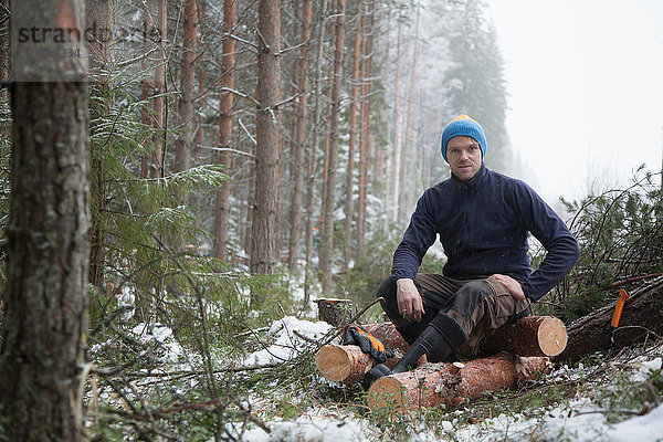 Holzfäller macht Pause bei Baumstämmen  Tammela  Forssa  Finnland