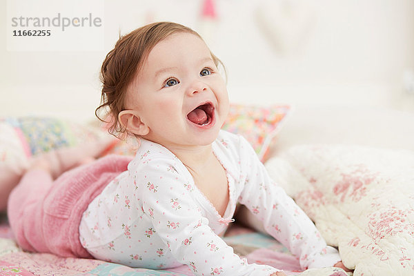 Porträt eines kleinen Mädchens  auf der Vorderseite liegend  lachend
