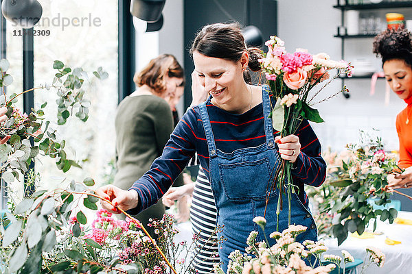 Floristikstudentin wählt Schnittblumen bei Blumenarrangement-Workshop aus