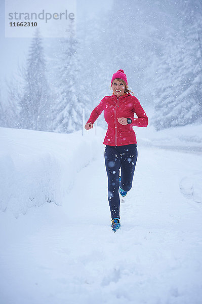 Läuferin läuft bei Schneefall  Gstaad  Schweiz