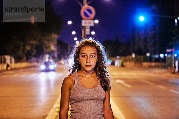Porträt einer Teenagerin mitten auf der Straße  die in die Kamera schaut