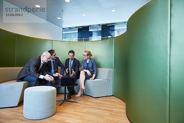 Geschäftsleute und Geschäftsfrau treffen sich auf dem Bürosofa