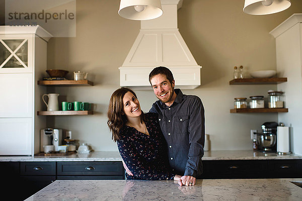 Porträt eines Paares mittlerer Erwachsener an der Küchentheke