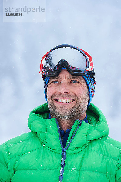Porträt eines glücklichen reifen Mannes im Schneefall  Gstaad  Schweiz