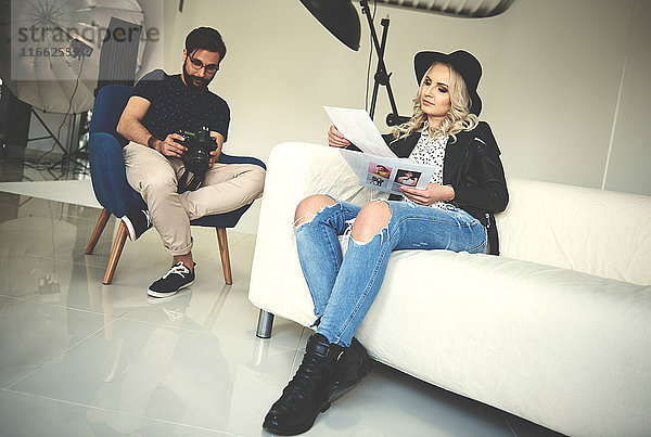 Fotograf und Stylist bei der Überprüfung der Arbeit im Fotostudio