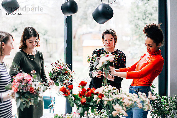 Florist und Studenten arrangieren Blumensträuße im Blumenarrangement-Workshop