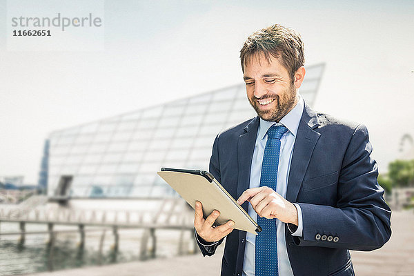 Geschäftsmann benutzt digitalen Tablet-Touchscreen am Stadtrand