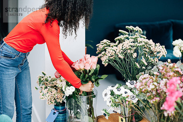 Floristinnen arrangieren Rosen in Vase für Ladenpräsentation