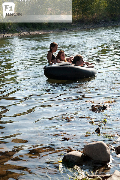 Damen fahren in Gummiflößen auf dem Fluss