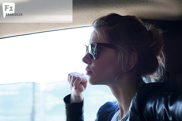 Frau mit Sonnenbrille  die in einem Auto reist