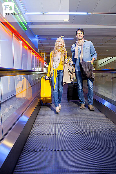 Ehepaar auf Fahrsteig im Flughafen