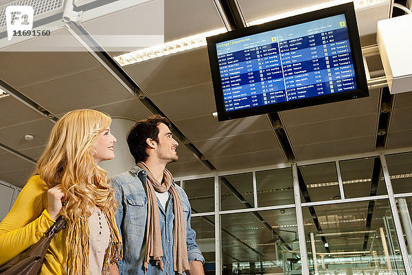 Paar  das Flugzeiten im Flughafen kontrolliert