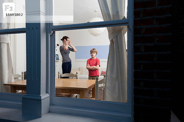 Mutter und Sohn durch Fenster betrachtet