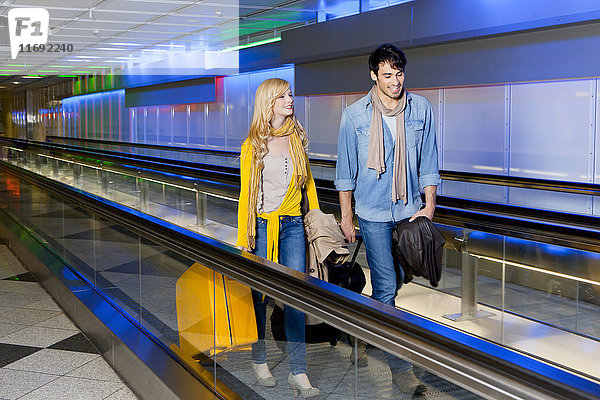 Ehepaar auf Fahrsteig im Flughafen