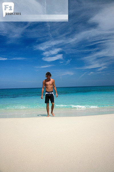 Mann geht am tropischen Strand spazieren