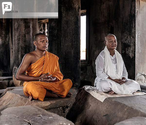 Älterer und junger Mönch beim Meditieren im Tempel in Angkor Wat  Siem Reap  Kambodscha
